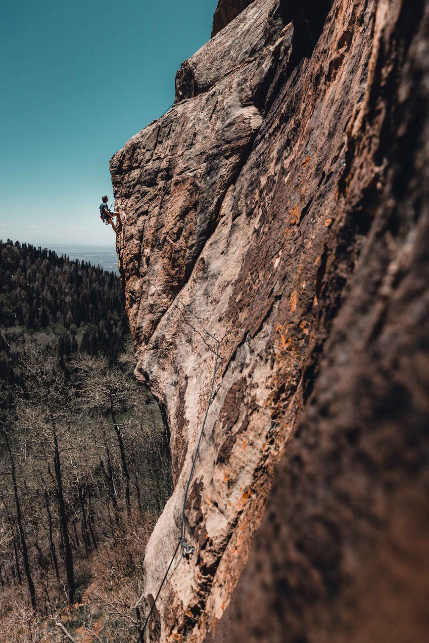 photo of man rock climbing